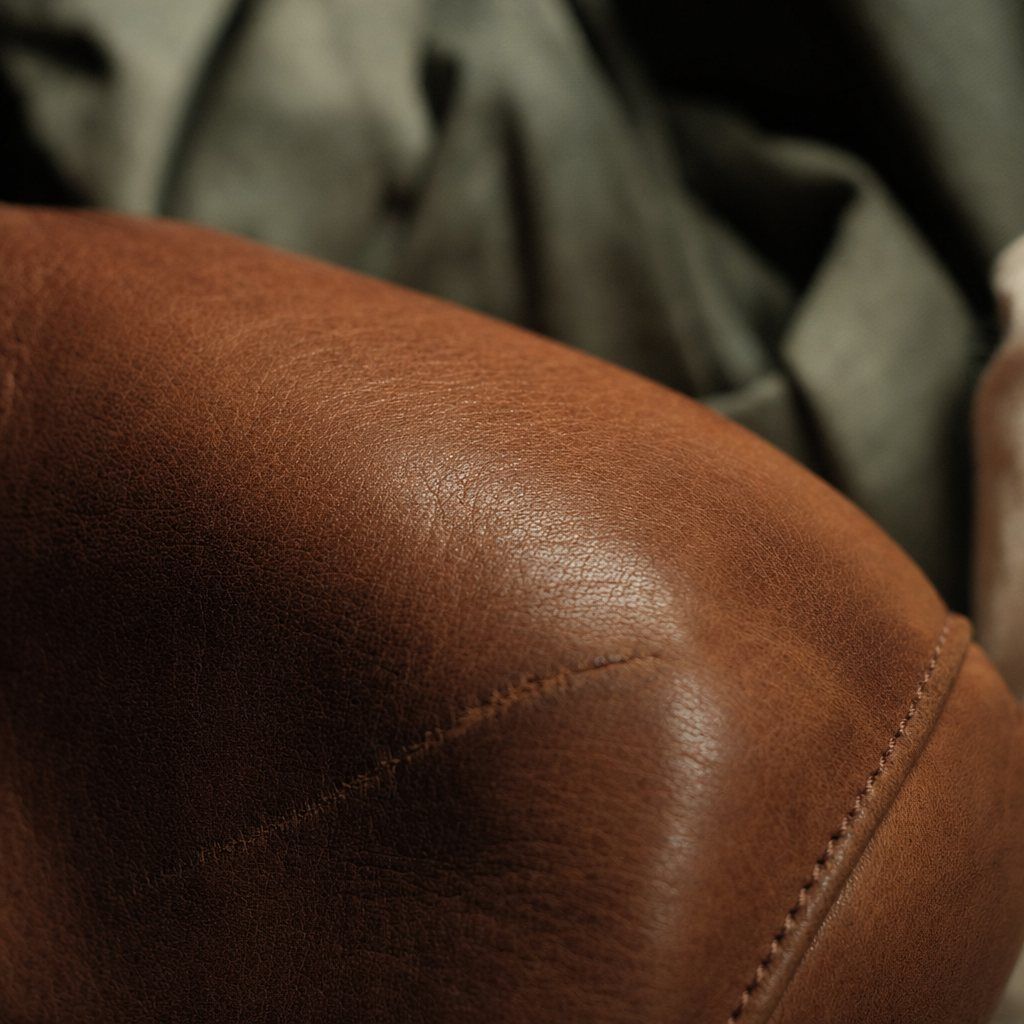 Close-up of full grain cognac leather with visible pores, natural wrinkles and a faint healed scar